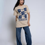 Woman wearing a beige t-shirt with a blue mascot checkered design and 'Cornerstone' text.