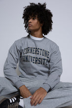 Load image into Gallery viewer, Person wearing a gray &#39;Cornerstone University&#39; crew sweatshirt sitting on a white background