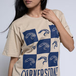 Woman wearing a beige t-shirt with a blue mascot checkered design and 'Cornerstone' text.