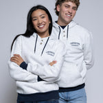 Two people wearing light hoodies with 'Cornerstone University' printed on them against a plain background