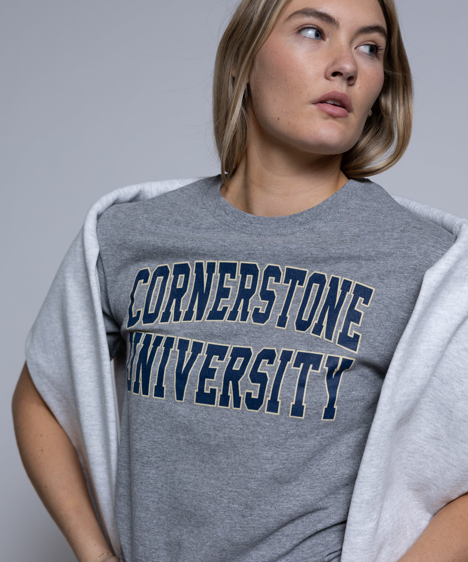 Person wearing a gray 'Cornerstone University' t-shirt against a plain background