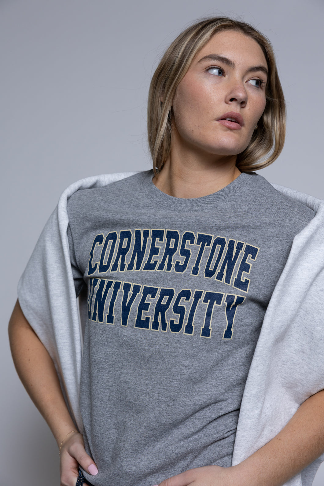 Person wearing a gray 'Cornerstone University' t-shirt against a plain background
