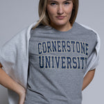 Person wearing a gray 'Cornerstone University' t-shirt against a plain background