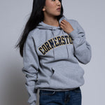 Woman wearing a gray hoodie with 'Cornerstone' text on a plain background