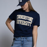 Woman wearing a navy 'Cornerstone University' t-shirt and cap on a plain background