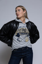 Load image into Gallery viewer, Person wearing a black leather jacket over a gray hoodie with Cornerstone basketball graphics on a plain background
