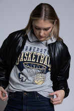 Load image into Gallery viewer, Person wearing a black leather jacket over a gray hoodie with Cornerstone basketball graphics on a plain background
