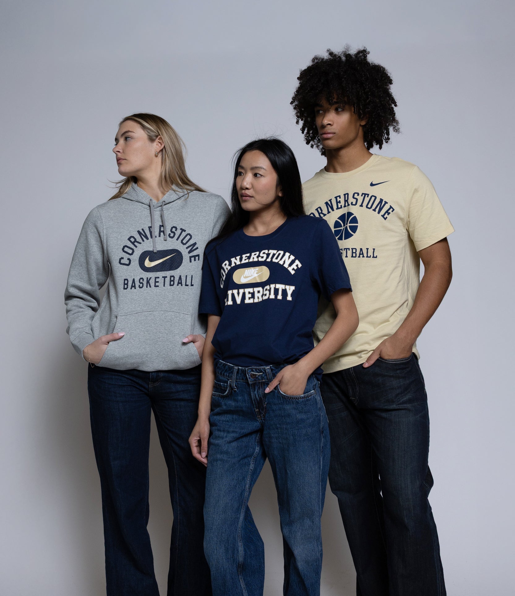 Three people wearing Cornerstone University Nike clothing on a plain background