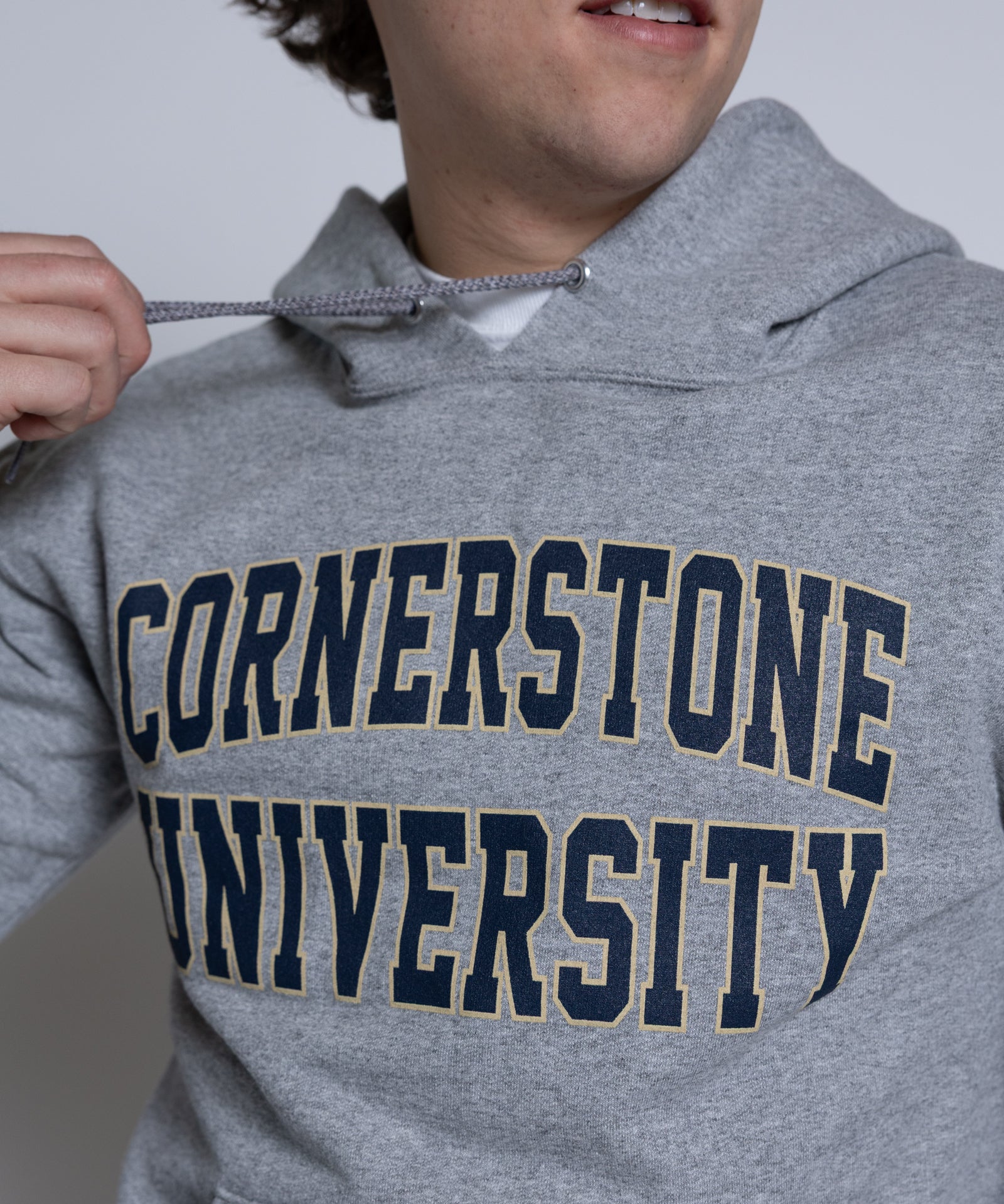 Person wearing a gray hoodie with 'Cornerstone University' printed on it.
