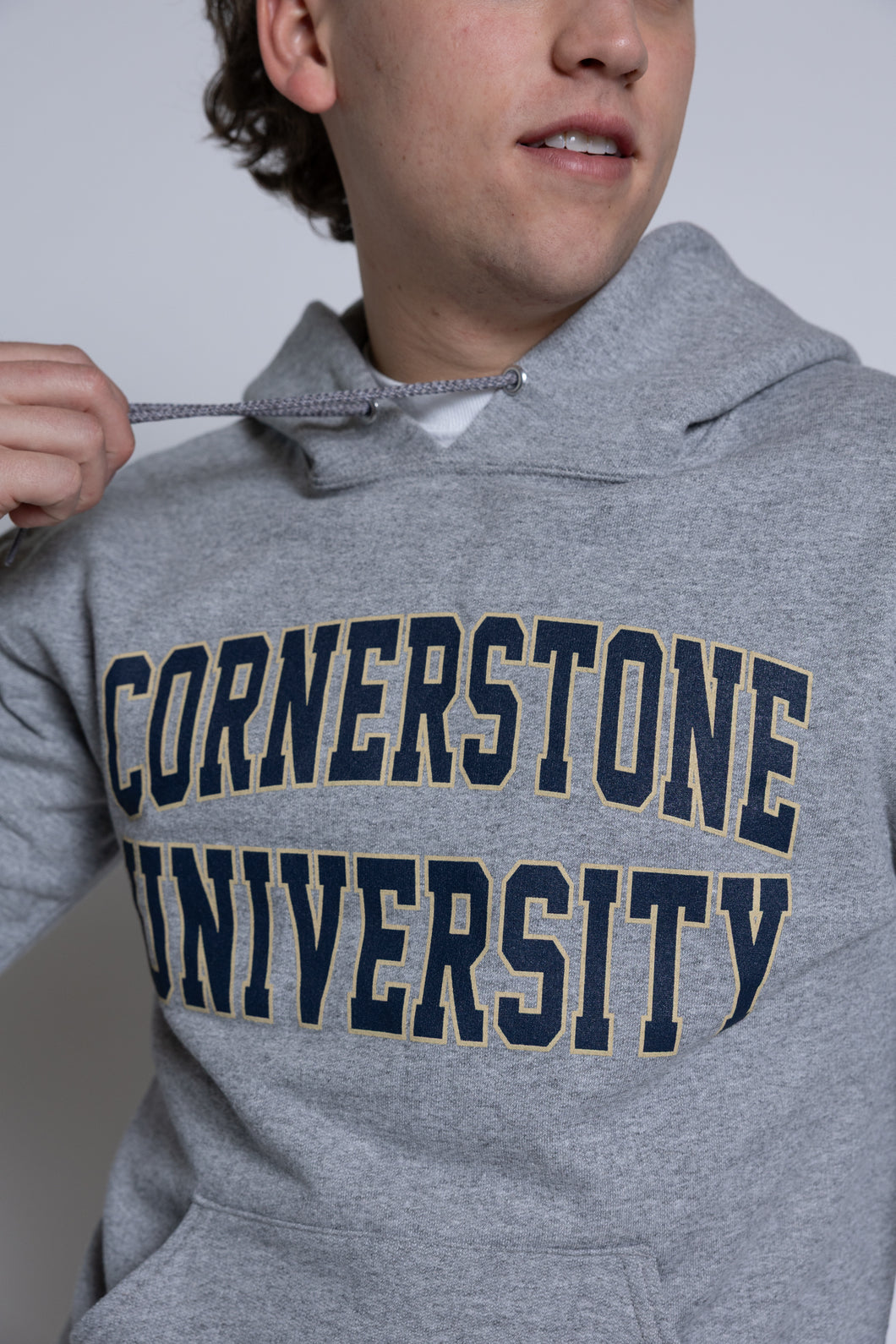 Person wearing a gray hoodie with 'Cornerstone University' printed on it.